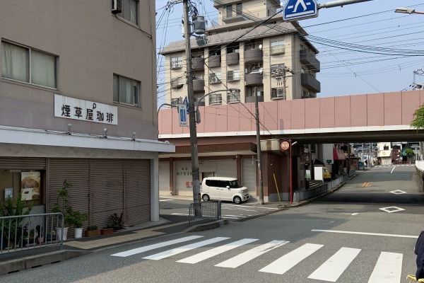 橋を渡ると煙草屋珈琲店がある交差点を右（阪急電鉄高架方面）に進みます。
高架をくぐり、大通り（176号線）までお進みください。