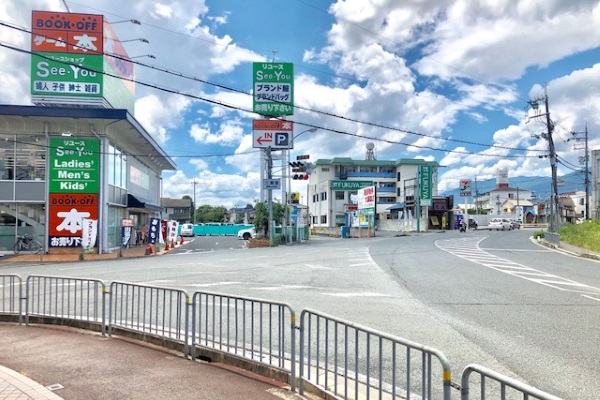 歩道をまっすぐ進んでいくと、弊社の看板が見えてきます。