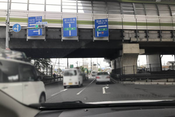 油小路通より東側（竹田駅側）に入ります。目印は名神高速道路の高架北側すぐの北西にスーパー銭湯（力の湯）、北東にバイクショップ（ホンダドリーム）がある交差点です