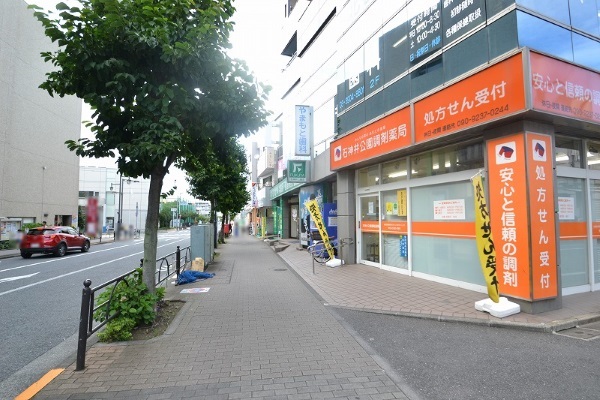 オレンジ色の看板の石神井公園調剤薬局が見えます。